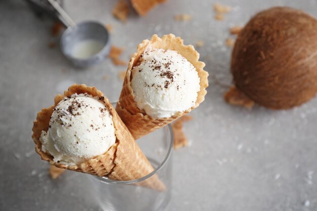 Foto conos de waffle con bolas de helado de coco en vidrio sobre mesa