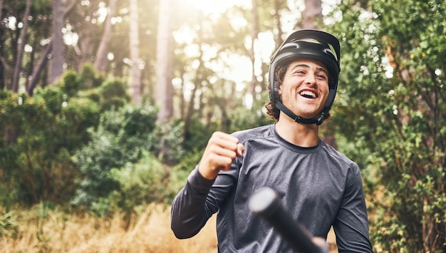 Conquista de mountain bike e comemorar vitória de sucesso ou liberdade em bicicleta na floresta florestal em uma aventura de ciclismo na natureza Homem de fitness em bicicleta parecendo feliz em viagem de bicicleta com capacete na Noruega