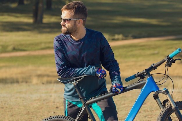 Conquistando picos de montanhas por ciclista de shorts e jersey em uma moderna bicicleta rígida de carbono