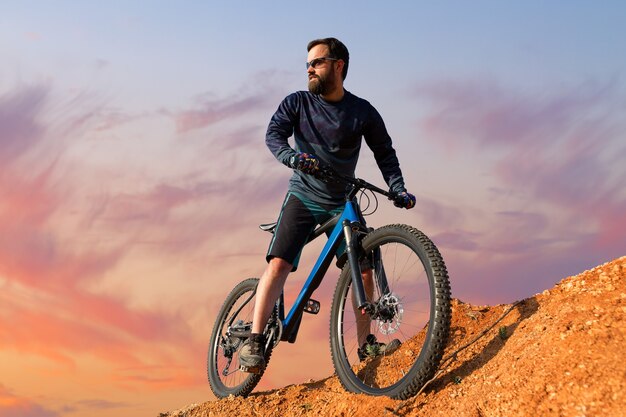 Conquistando los picos de las montañas por ciclista en pantalones cortos y maillot en una moderna bicicleta rígida de carbono