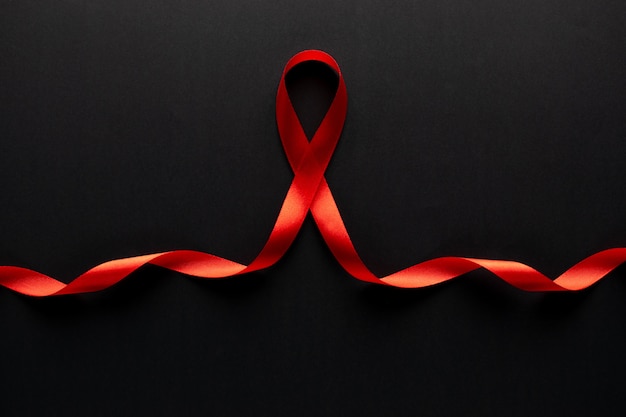 Foto conscientização do close up da fita vermelha em papel preto para a campanha do dia mundial da aids.