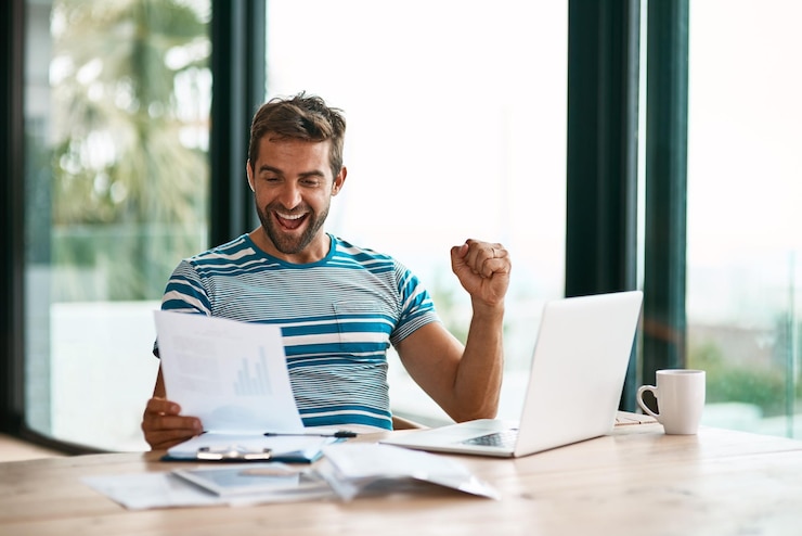 Foto consegui o acordo foto recortada de um jovem empresário bonito torcendo enquanto trabalhava em seu escritório em casa