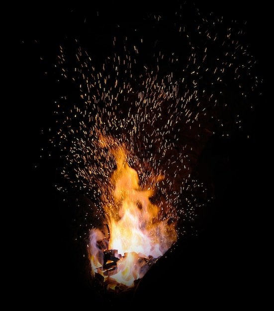 Consejos de llama de fuego de herrería con chispas closeup sobre fondo oscuro