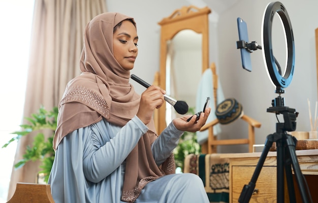 Consejos de maquillaje para las celebraciones de Eid de este año Foto de una joven musulmana ocupada grabándola para su vlog