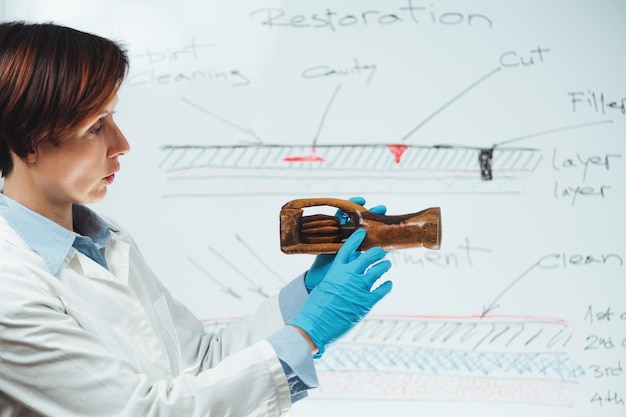 Foto conservadora profesional que explica la restauración de esculturas de madera