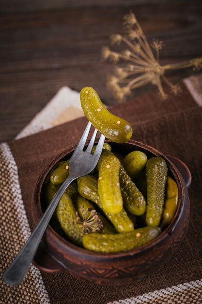 Foto conservando temperos de pepino em conserva e alho na mesa de madeira