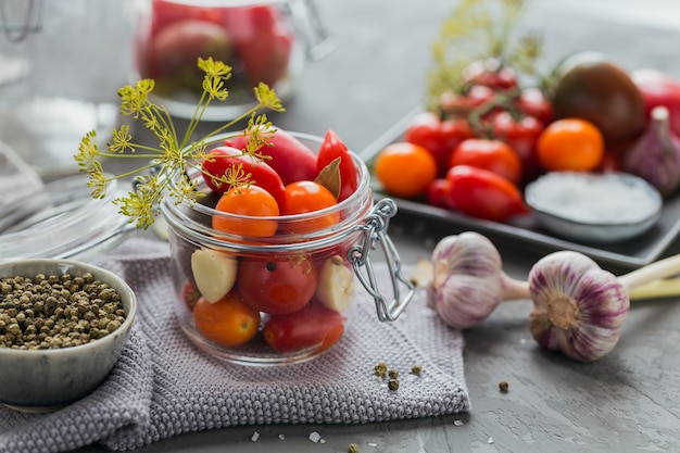 Conservas caseiras. Ingrediente para picles, tomate com endro na mesa da cozinha.