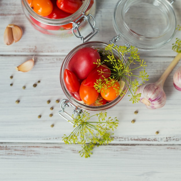 Conservas caseras. Ingrediente para tomates encurtidos con eneldo en la mesa de la cocina en un estilo rústico