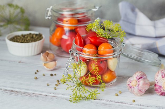 Conservas caseras. Ingrediente para tomates encurtidos con eneldo en la mesa de la cocina en un estilo rústico