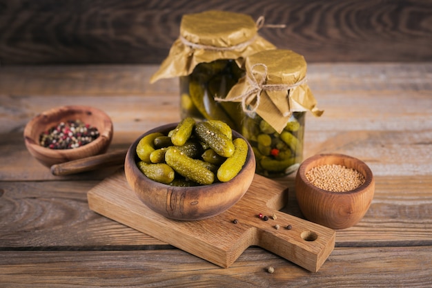 Conservas caseras. Pepinillos de pepinos marinados con eneldo y ajo en un frasco de vidrio sobre la mesa de madera. Ensaladas de verduras para el invierno.