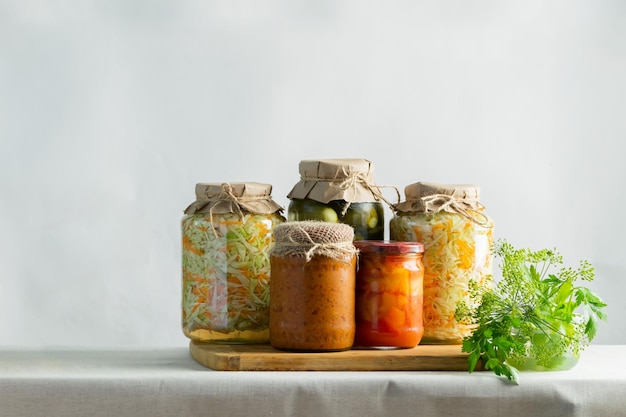 Conservas fermentadas o enlatadas varias verduras calabacín chucrut zanahorias pepinos en frascos de vidrio sobre la mesa