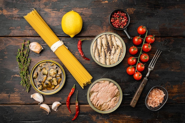 Conservas de pescado y marisco en latas de aluminio, sobre fondo de mesa de madera oscura antigua, vista superior plana