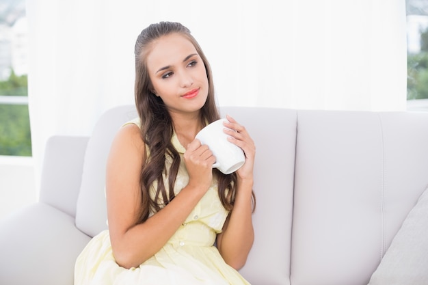 Considerado joven morena sosteniendo una taza