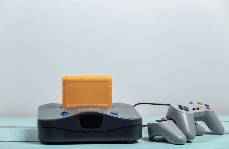 Consola de juegos retro y gamepads en una pared blanca. Juegos retro
