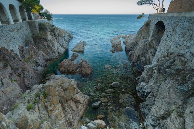 Foto construção com arco costa rochosa e mar translúcido