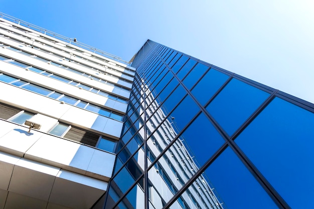 Construção de arranha-céus moderno de vidro em frente ao céu azul em perspectiva