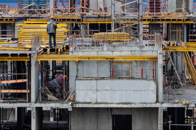 Construção de estrutura monolítica do edifício Trabalhadores que trabalham no canteiro de obras em casa A estrutura para as paredes Cofragem para paredes feitas de canteiro de obras de concreto close-up