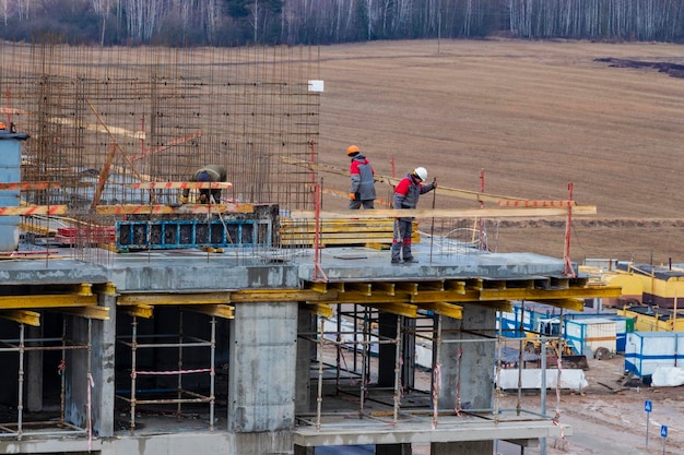 Construção de estrutura monolítica do edifício Trabalhadores que trabalham no canteiro de obras em casa A estrutura para as paredes Cofragem para paredes feitas de canteiro de obras de concreto close-up