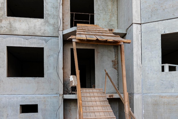 Construção de uma casa de betão armado com painéis de vários pisos. rampa segura na entrada do prédio. segurança do canteiro de obras.
