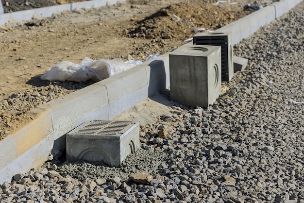 Construção do pavimento, grelha em um poço para uma base de concreto durante o assentamento de drenagem de água