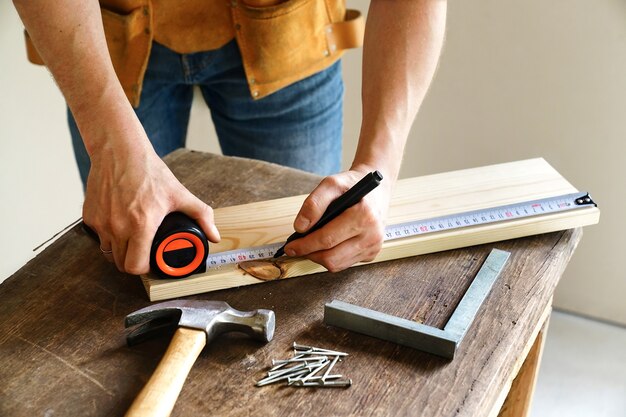 Foto construção e reparo. carpintaria. trabalhador marca o tabuleiro