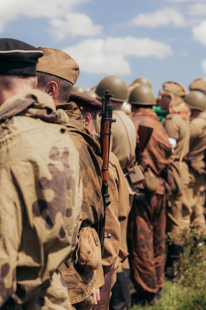 Foto construção militar de soldados durante a reconstrução das hostilidades em maio, uma área estreita de nitidez, foco no rifle. foto de alta qualidade