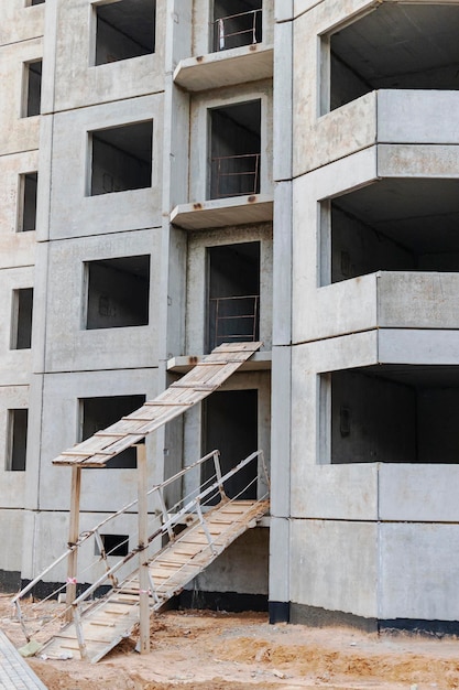 Construcción de una casa de concreto reforzado con paneles de varios pisos Rampa segura en la entrada del edificio Seguridad en el sitio de construcción