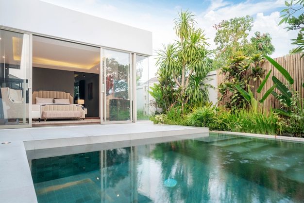 Construcción de casas o casas Diseño exterior e interior que muestra una villa con piscina tropical con jardín verde