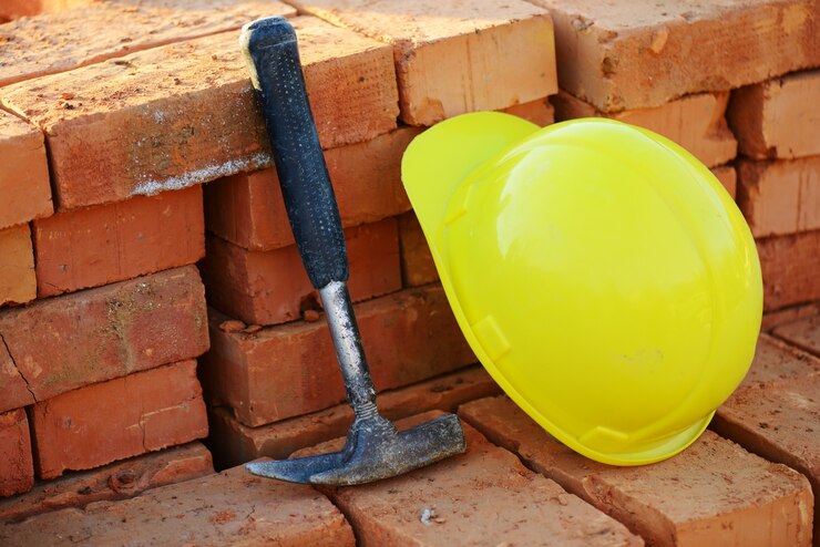 Foto en construcción, casco y ladrillos para el sitio de construcción
