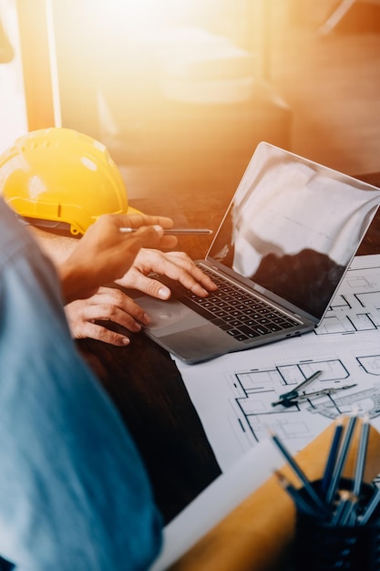 Construcción y concepto de estructura del ingeniero que trabaja dibujando en el plan de reunión para el proyecto que trabaja con el socio en la construcción de modelos y herramientas de ingeniería en el concepto de construcción del sitio de trabajo
