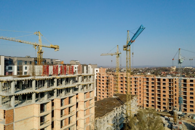 Construcción y construcción de edificios de gran altura, la industria de la construcción con equipos de trabajo y trabajadores. Vista desde arriba, desde arriba.