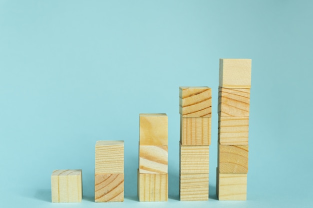 Foto construcción de cubos de madera sobre fondo azul con espacio de copia. composición de la maqueta para el diseño