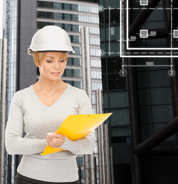 construcción, desarrollo, construcción, concepto de arquitectura - contratista femenina en casco blanco con plano