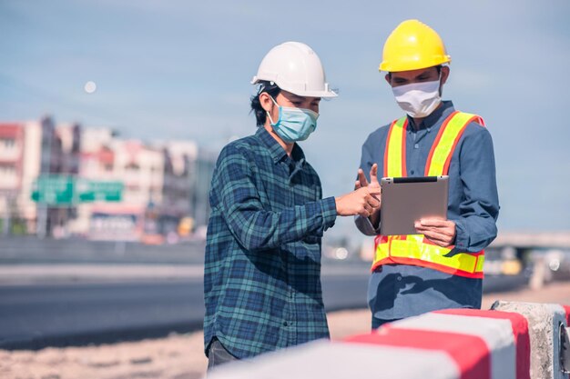 La construcción de ingenieros asiáticos es un trabajador que trabaja con un casco de control de seguridad en el edificio del sitio