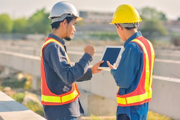 La construcción de ingenieros asiáticos es un trabajador que trabaja con un casco de control de seguridad en el edificio del sitio