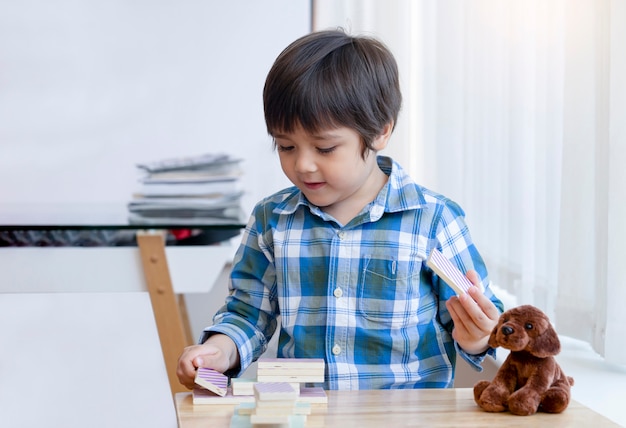 Construcción inteligente de aprendizaje para niños con bloques de colores de madera, juego de construcción de juegos de dominó de madera para niños felices, niño de 5 años jugando a la torre de bloques de dominó de colores