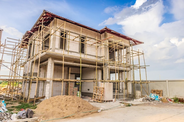 Construcción de nueva casa residencial en curso en el sitio de construcción con nubes y cielo azul