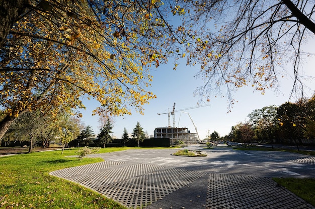 Foto construcción de una nueva zona residencial de edificios de gran altura cerca del parque de la ciudad de otoño