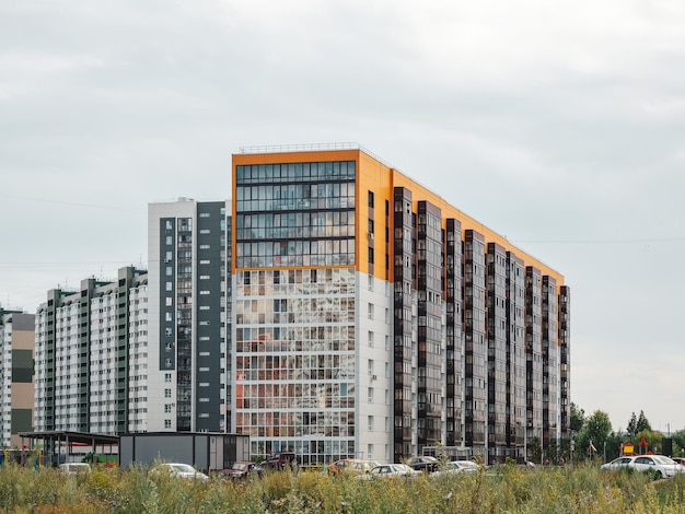Construcción de paneles modernos nueva zona residencial Hermosos y coloridos edificios nuevos Pared coloreada contra un cielo azul nublado Copiar espacio