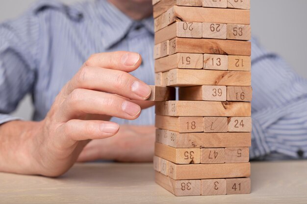 Construcción de torre de bloques de madera Decisiones de estrategia empresarial y concepto de gestión