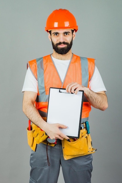 Un constructor con un casco naranja en un fondo gris firma algo