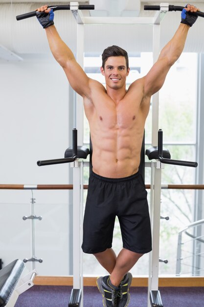 Constructor de cuerpo masculino sin camisa haciendo pull ups