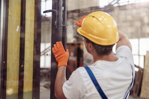 Constructor masculino reparación de puerta en edificio en construcción