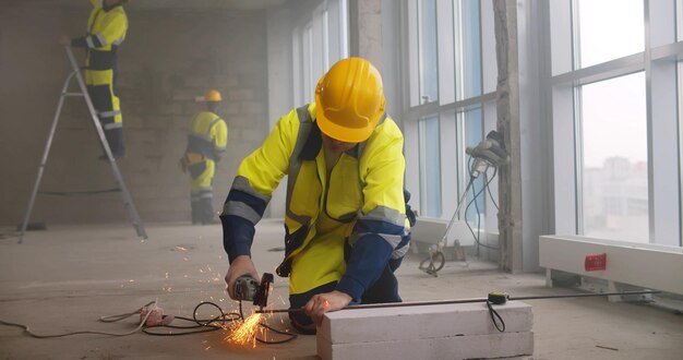 Constructor usando barra de acero de corte de amoladora de metal en el sitio de construcción