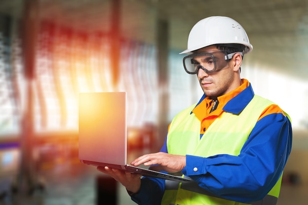 Constructores de hombres en la aldea trabajando en una computadora portátil con antecedentes de contracción