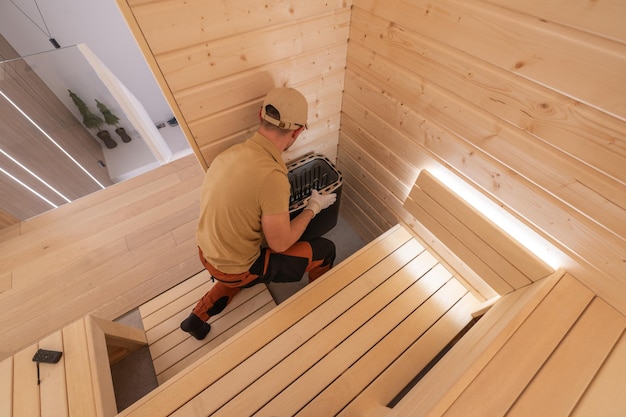 Construidor em seus 40 anos terminando uma sauna finlandesa residencial