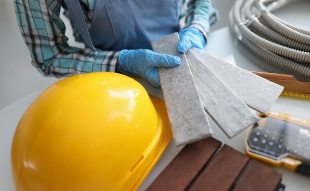 Foto construidor segurando telhas cinzentas para banheiro em close-up de oficina