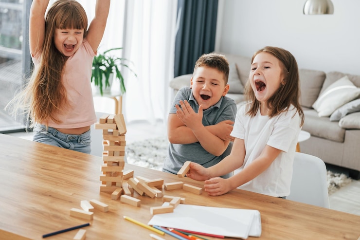 Foto construindo uma torre jogando o jogo crianças se divertindo na sala doméstica durante o dia juntos