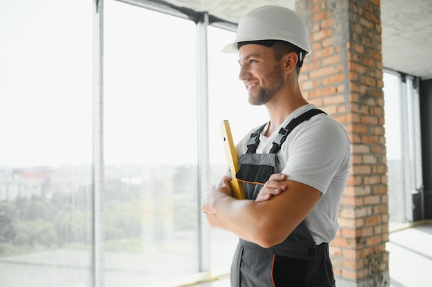 Construtor de homem trabalhando no canteiro de obras Reparador masculino de macacão e capacete