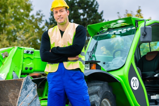 Construtor em frente a maquinaria de construção